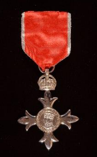 An MBE: a red ribbon and suspended below a crown and then cross